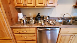 A kitchen with wooden cabinets, stainless steel appliances, and a sink. - Connors Lake Landing - Home/Hangar & Federal License Grass Runway - 2WS2 (Webster)