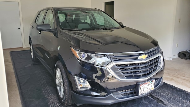 A black Chevrolet SUV parked in a garage with a black mat on the floor. - Connors Lake Landing - Home/Hangar & Federal License Grass Runway - 2WS2 (Webster)