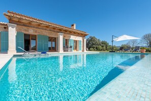 An infinity pool, pool umbrellas, pool loungers