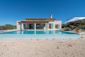 An infinity pool, pool umbrellas, pool loungers