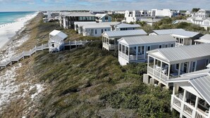 Zona costera con casas de playa, algunas con balcones, y una vista despejada de la playa y el océano.