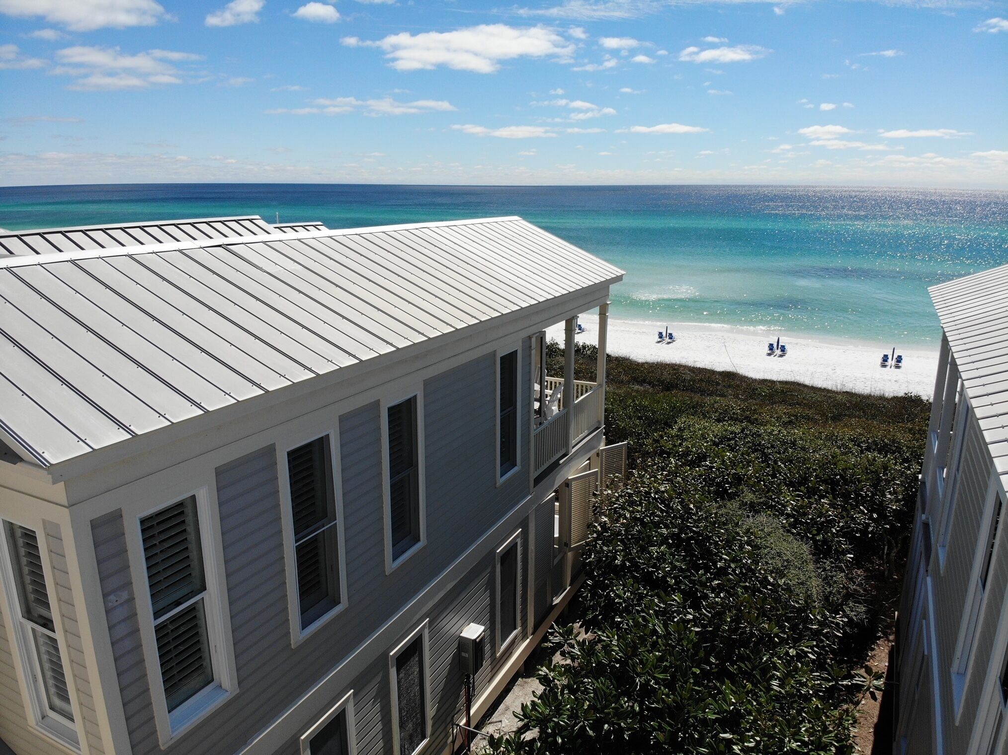 A beachfront property with a balcony overlooking the ocean.