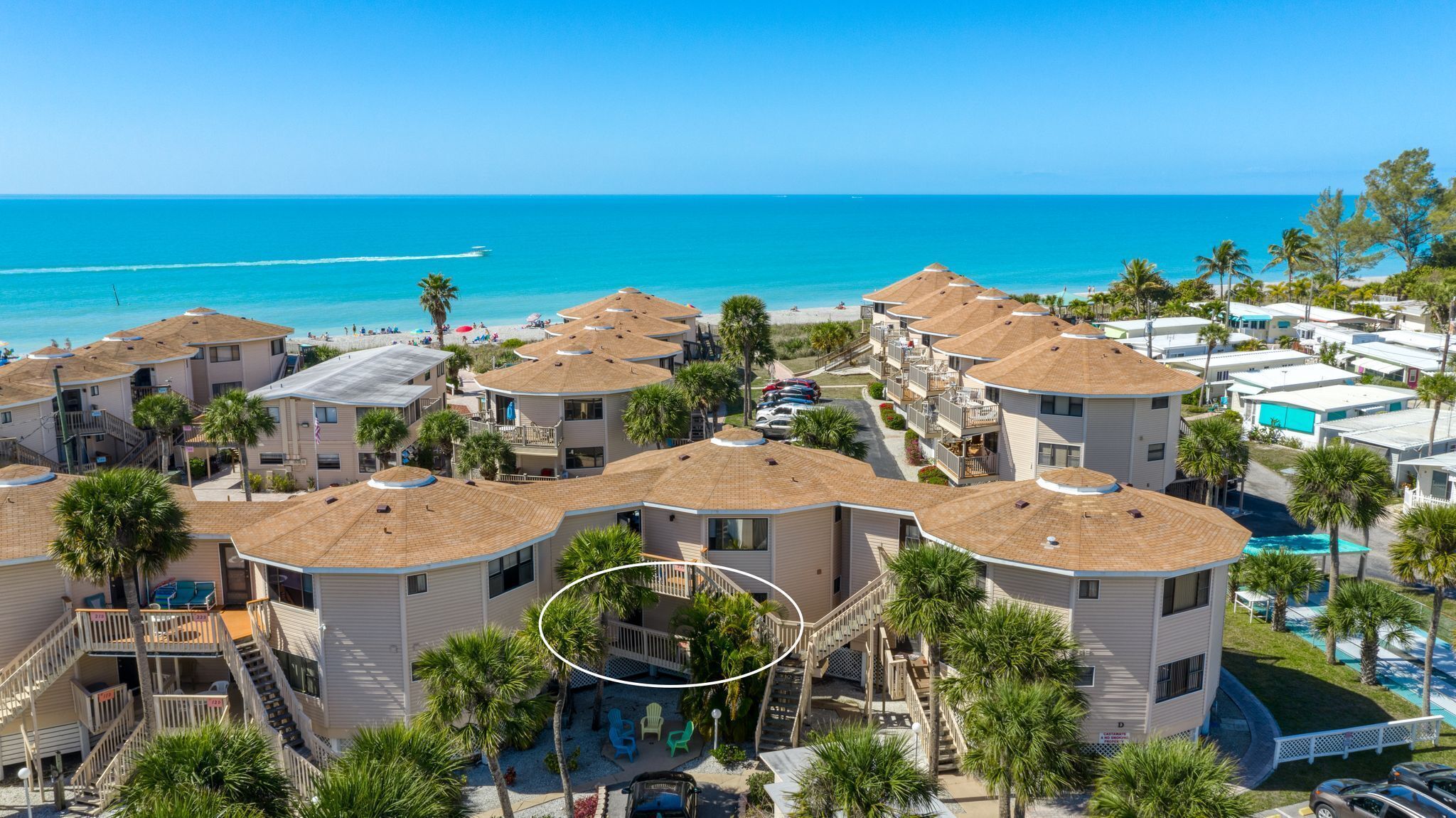Un complexe hôtelier situé en bord de mer, composé de bâtiments à plusieurs étages, doté d’une piscine et offrant une vue sur la plage.