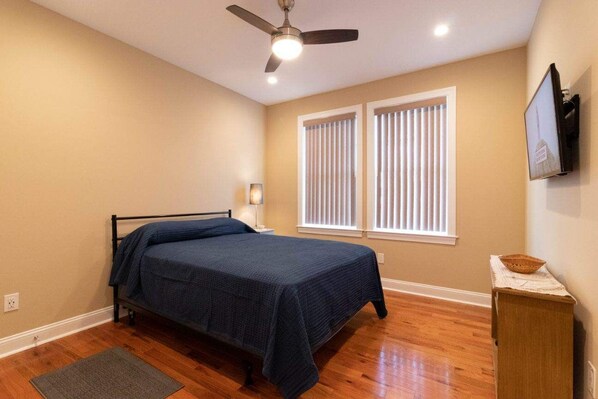 A bedroom with a bed, a ceiling fan, a window with blinds, and a television on the wall. - Beaches/Shopping/Dining/Breweries (Rehoboth Beach)