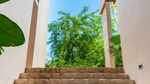 A set of stone steps leading up to a covered area with a view of lush green trees and a clear blue sky. - Apartment With Private Plunge Pool - Ground Floor by Sessile (Tulum)