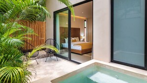 A modern bedroom with a large bed, a glass door leading to a balcony, and a small seating area with chairs and a table. - Apartment With Private Plunge Pool - Ground Floor by Sessile (Tulum)