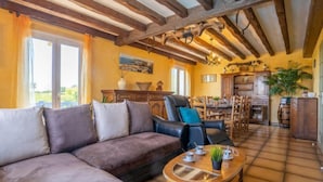 A cozy living room with a sofa, a dining table, and a kitchen area.