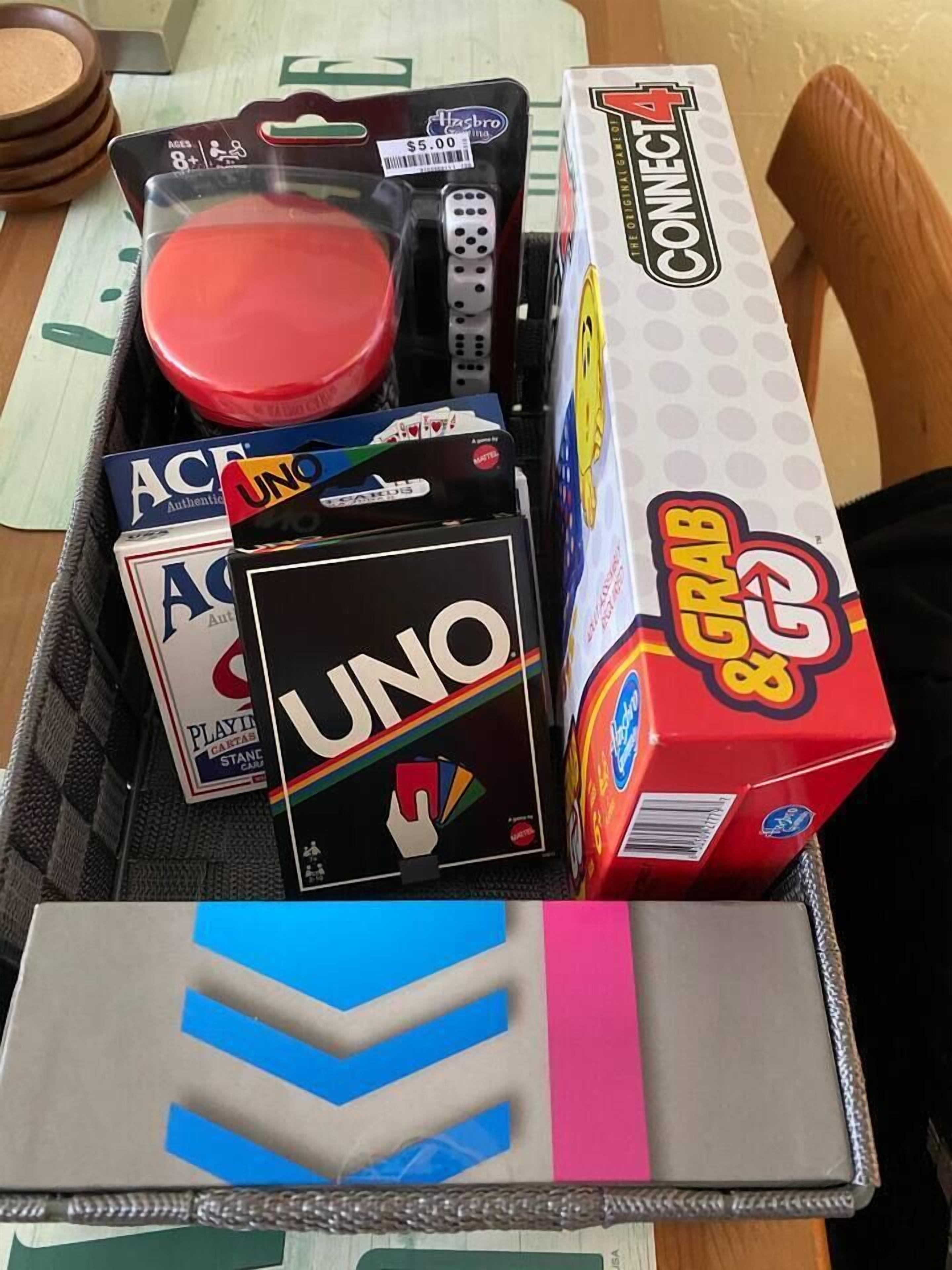 Une boîte de cartes UNO, un jeu Connect 4 de la marque Hasbro et un jeu de cartes classique.