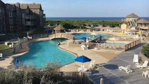 A resort with multiple swimming pools, a wooden deck, and a view of the ocean. - BIS-Duck - 2BR/2BA - First Floor, Great Beach and Pools! (Duck)