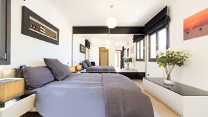 Une chambre moderne avec un grand lit, des tables de chevet, une lampe de chevet, un miroir et une fenêtre donnant sur un beau paysage.