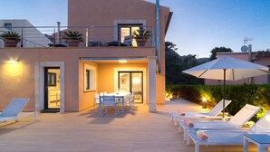 Un bâtiment moderne doté d’un balcon, d’un espace extérieur aménagé et d’un coin repas.