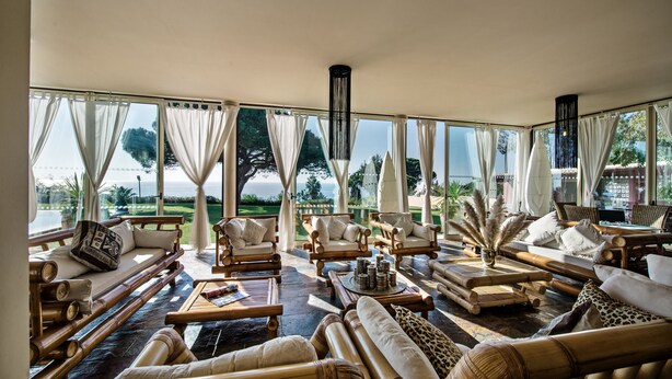 Un salón amplio con ventanas grandes, asientos cómodos y vistas al exterior.