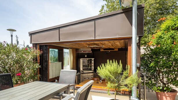 An outdoor patio area with a table, chairs, a small tree, and a grill. - Apartment "Zur Imme" with Mountain View, Wi-Fi and Air Conditioning (Lindau)