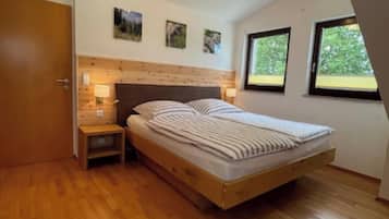 Ein Schlafzimmer mit einem hölzernen Bett, einem Nachttisch, einer Wandleuchte und einer Deckenlampe.