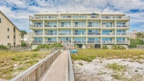 A multi-story hotel with balconies, a beach view, and a boardwalk leading to the beach. - Right on the Beach - Pool - 1BR 1BA - King & Bunks (Santa Rosa Beach)