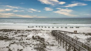 A beach with a wooden boardwalk leading to beach chairs and umbrellas. - Right on the Beach - Pool - 1BR 1BA - King & Bunks (Santa Rosa Beach)