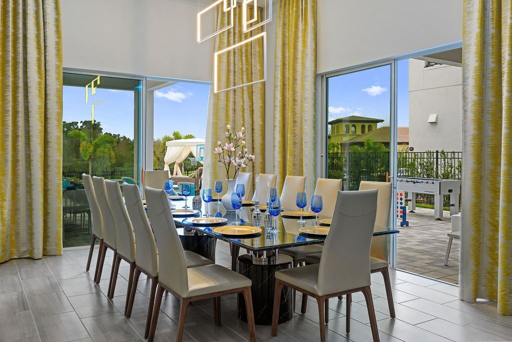 Un coin repas avec une table en verre, des chaises et de la verrerie bleue.
