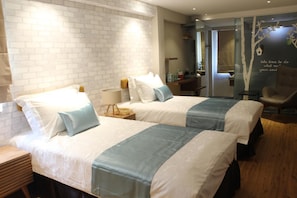 A hotel room with two beds, a wooden nightstand, a desk, and a chair. - Sojourn Guest House (Ampang)