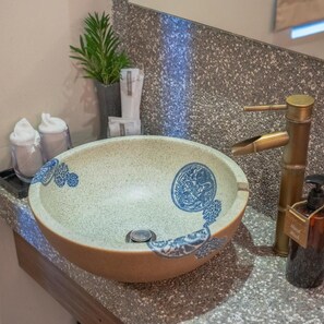 A bathroom sink with a round basin, a faucet, and a hand soap dispenser. - Sojourn Guest House (Ampang)