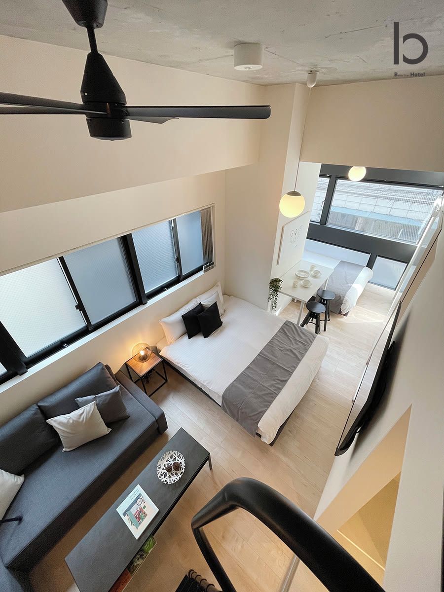 Une chambre d’hôtel moderne équipée d’un lit, d’un canapé, d’un bureau et d’un coin repas.