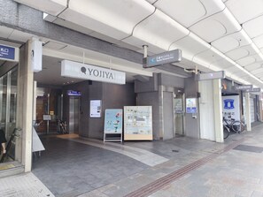 A hotel entrance with a sign for 'YOJIYA' and 'Kyoto Central Inn,' an elevator, and a bike rack. - Kyoto Central Inn (Kyoto)