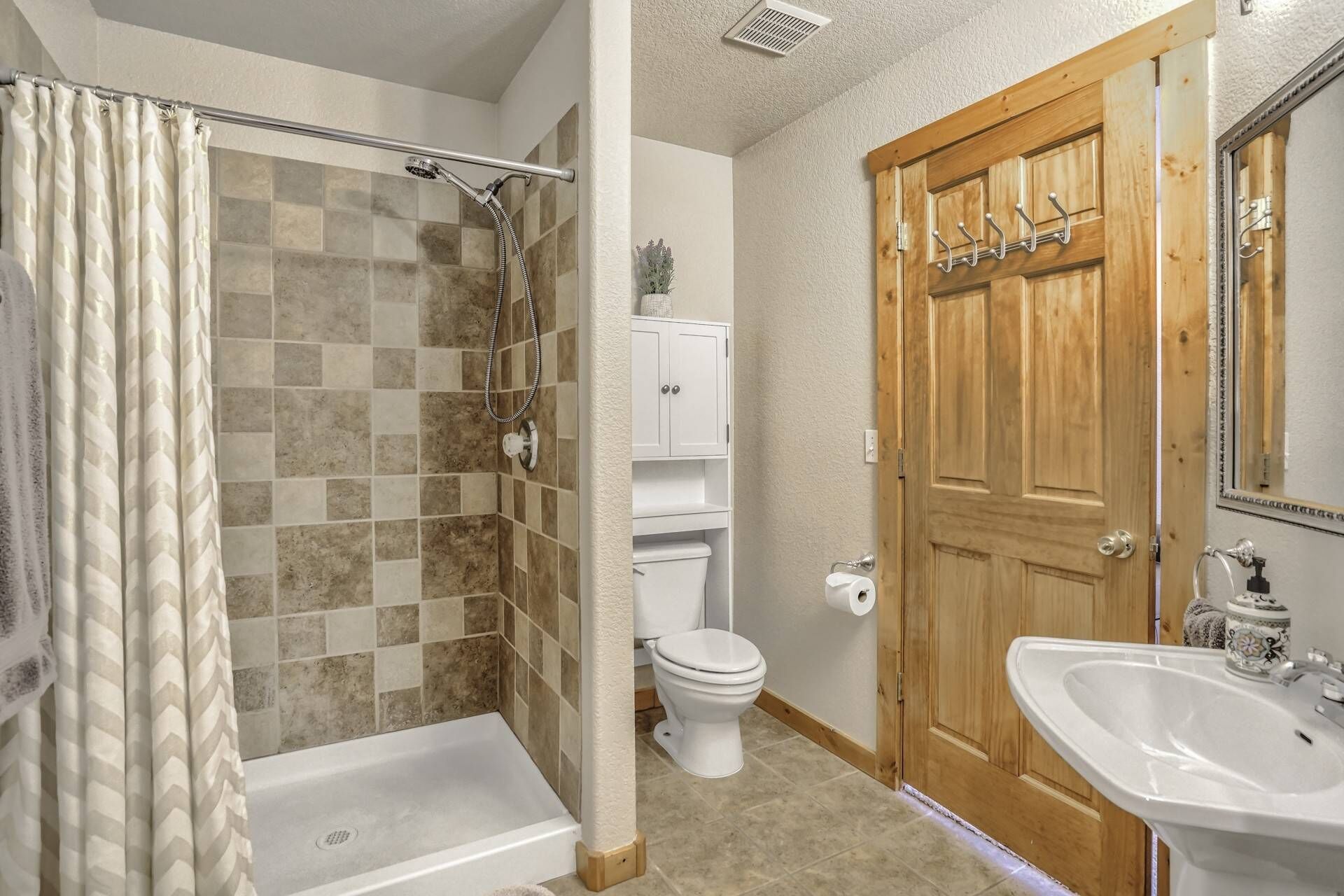 A bathroom with a shower, toilet, and sink.