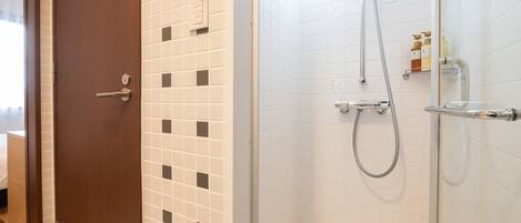 Une salle de bain avec une douche, des toilettes et un lavabo.
