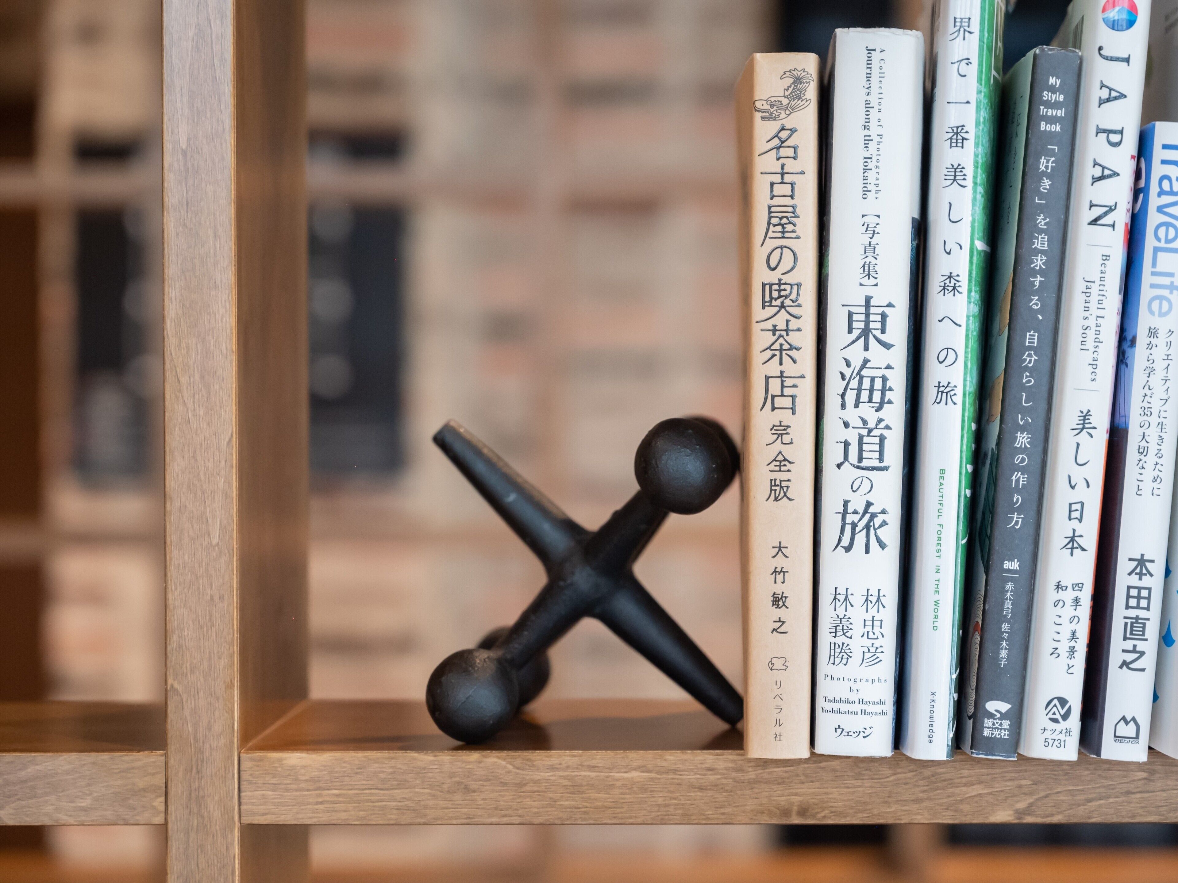 Une bibliothèque avec des livres et un objet noir.