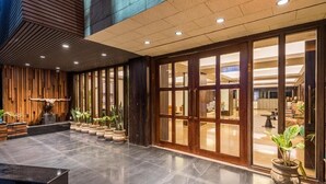 A spacious lobby with a polished floor, wooden paneling, and potted plants. - Udaan Himalayan Suites and Spa (Darjeeling)
