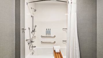 A modern bathroom with a bathtub, shower, and towel rack.