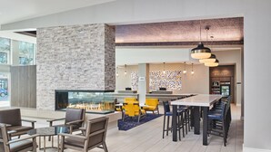 A modern lobby with a fireplace, seating areas, and a bar. - Residence Inn by Marriott Berkeley (Berkeley)