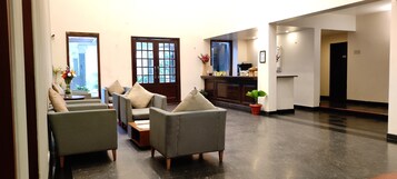 A spacious lobby with a reception desk, seating area, and a fireplace.