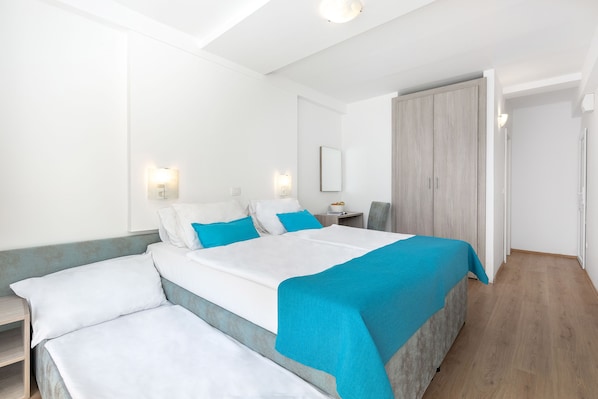 A modern hotel room with a large bed, bedside tables, and a wardrobe. - Annex Slaven (Crikvenica)