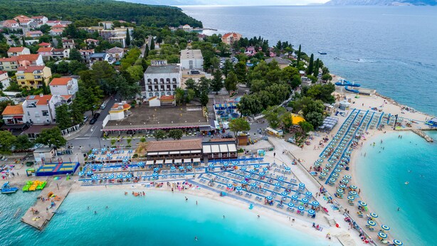A coastal hotel with multiple beachside amenities, including sun loungers and umbrellas, and a view of the sea. - Annex Slaven (Crikvenica)