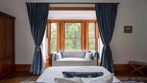 Un dormitorio con una cama grande, un armario de madera y una ventana con cortinas.