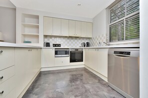 A kitchen with white cabinets, a microwave, an oven, and a dishwasher.