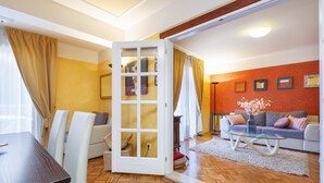 A modern living room with a wooden floor, a glass coffee table, a sofa, and a dining table with chairs. - Apartments with Shared Pool Villa Rossella 1 (Rovinj)