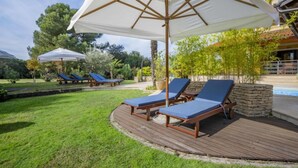 A poolside area with lounge chairs and umbrellas. - Apartments with Shared Pool Villa Rossella 1 (Rovinj)