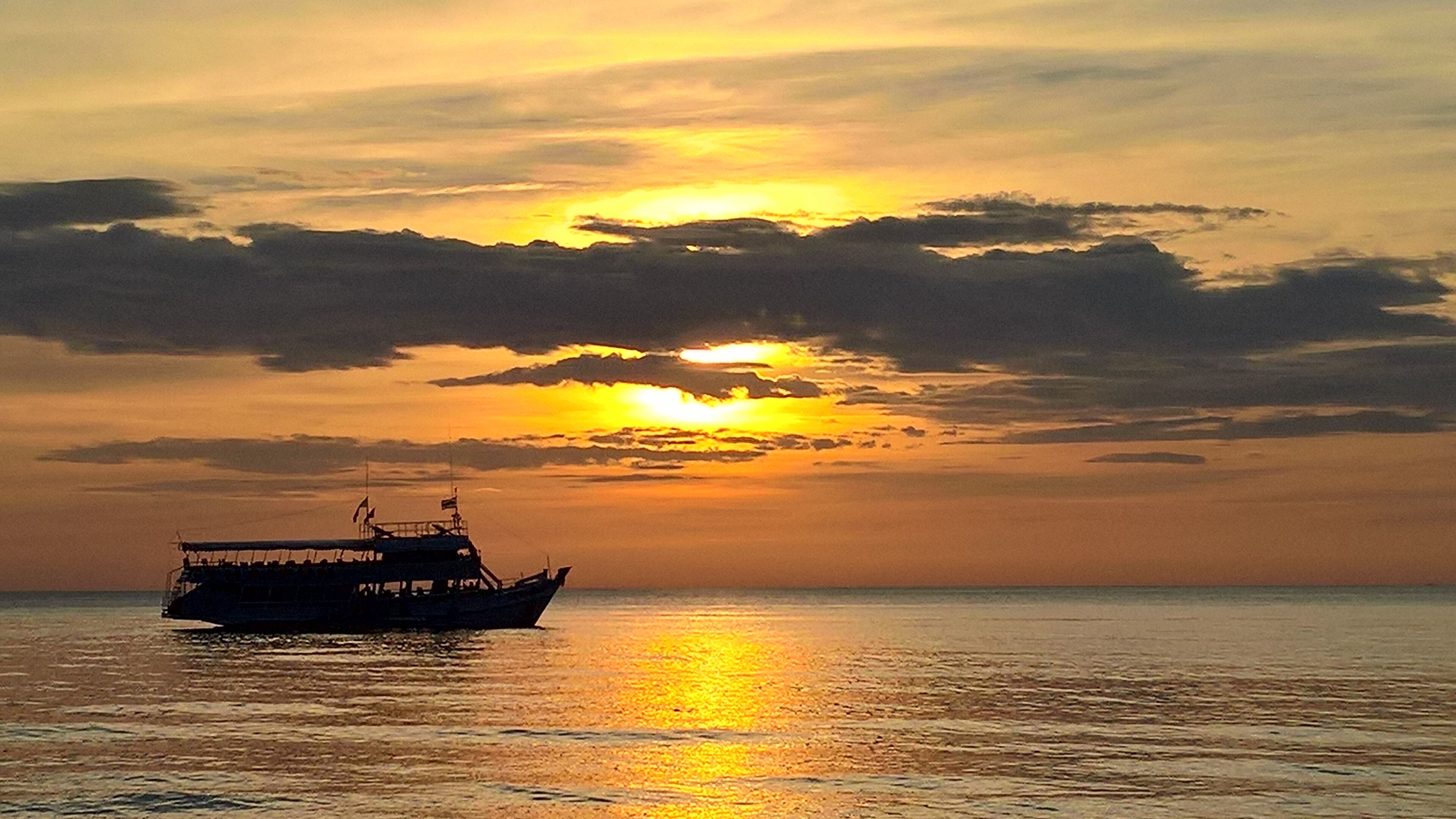 Een boot op kalm water tijdens de zonsondergang.