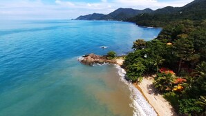 A coastal landscape with a beach, clear blue waters, and lush greenery. - Penny Bangalow Resort (Ko Chang)