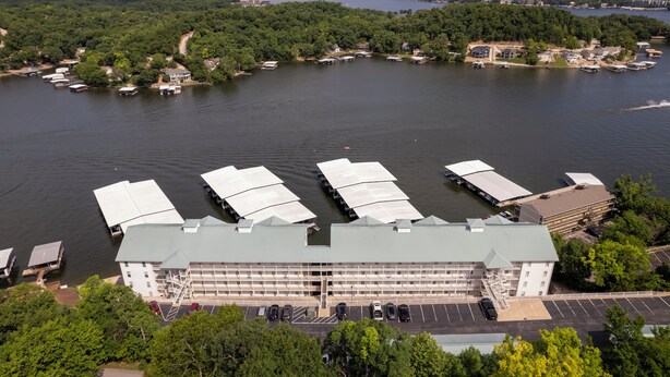 Un edificio grande con estacionamiento y barcos en un lago.