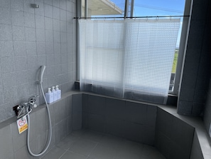 A modern shower area with a glass partition, a handheld showerhead, and a soap dispenser. - JAM ClubHouse Resort (Yomitan)