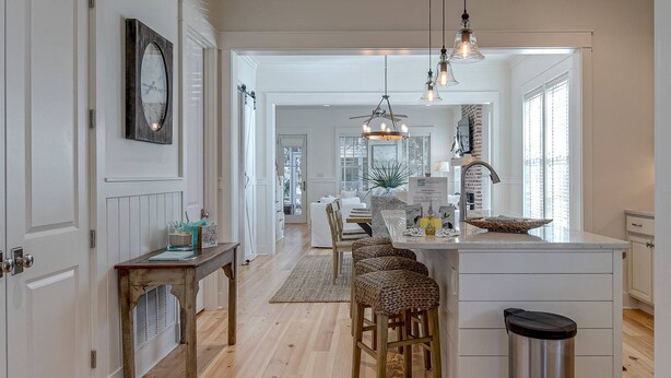 A modern kitchen with a central island, pendant lighting, and a view into the dining area. - Family-Friendly Home in Watercolor | Beach Club, *Golf Cart, Pool Access, Steps to Beach & Dining! (Santa Rosa Beach)