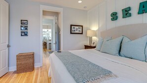 A bedroom with a bed, a bedside table, a lamp, and a wall with the word "SEA" spelled out in letters. - Family-Friendly Home in Watercolor | Beach Club, *Golf Cart, Pool Access, Steps to Beach & Dining! (Santa Rosa Beach)