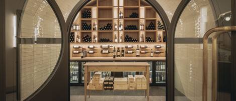 Una bodega con estantes de madera y una mesa central que exhibe cajas de vino.
