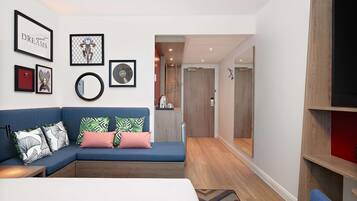 A modern living room with a blue sectional sofa, a coffee table, and a bookshelf.