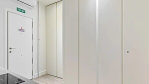 Käytävä, jossa on valkoinen ovi, jonka yläpuolella on teksti ”SALIDA”, sekä hätäuloskäyntiä osoittava opaste.