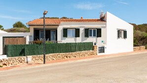A two-story building with a white facade, green shutters, and a tiled roof. - Mercè - House with sea view in Biniancolla (Biniancolla)