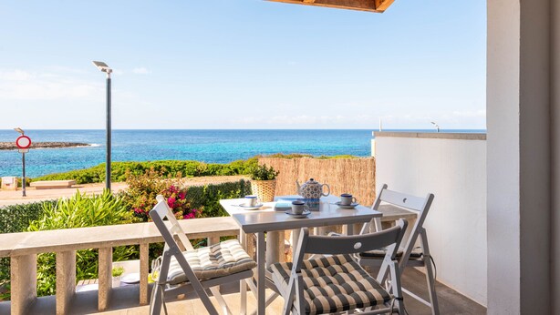 A balcony with a table and chairs, overlooking a coastal view. - Mercè - House with sea view in Biniancolla (Biniancolla)