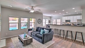 A modern kitchen with white cabinets, a central island, and bar stools. - Game Room, Putting Green! Queen Creek Family Home (Queen Creek)
